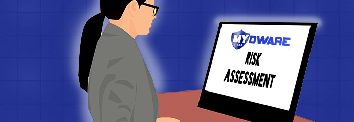 A MYDWARE technician reviewing a Risk Assessment report on a computer monitor
